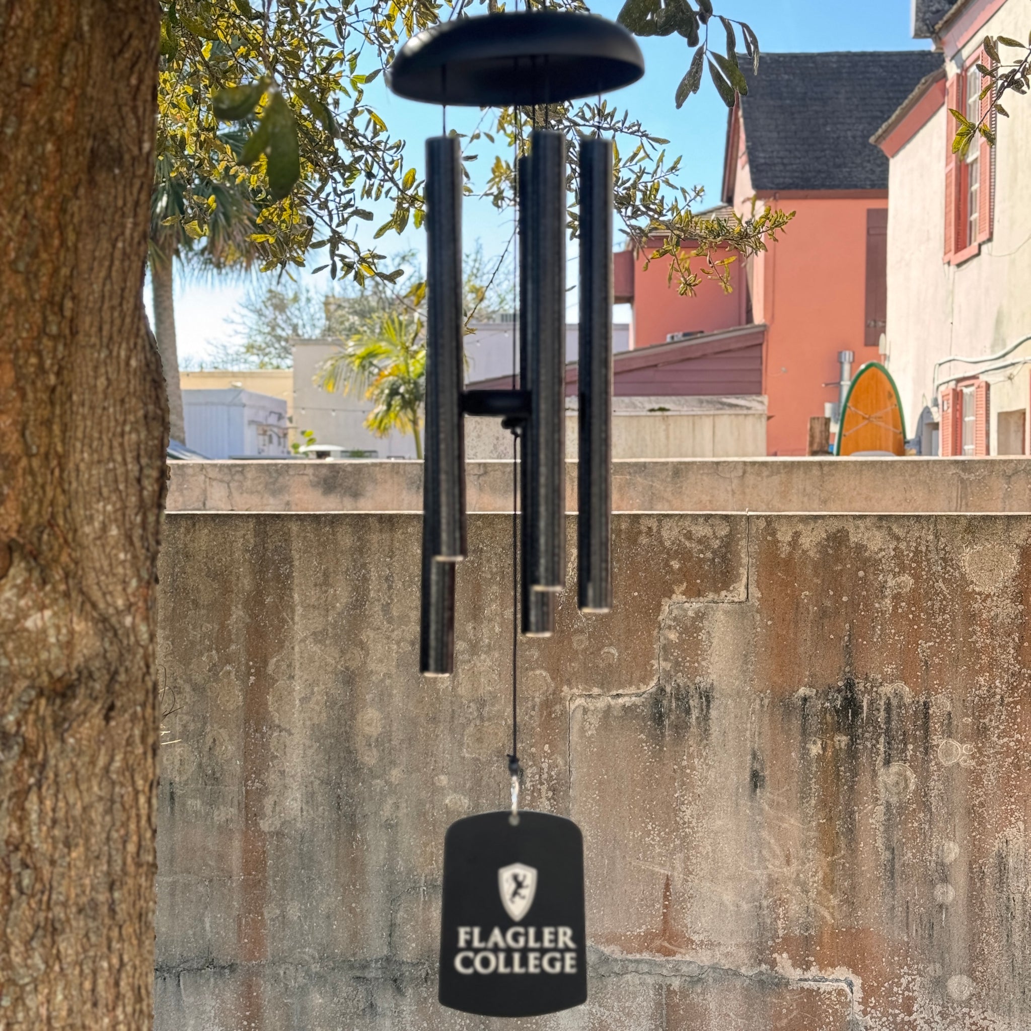 Black wind chime with white Flagler College Shield logo over white imprint saying Flagler over College