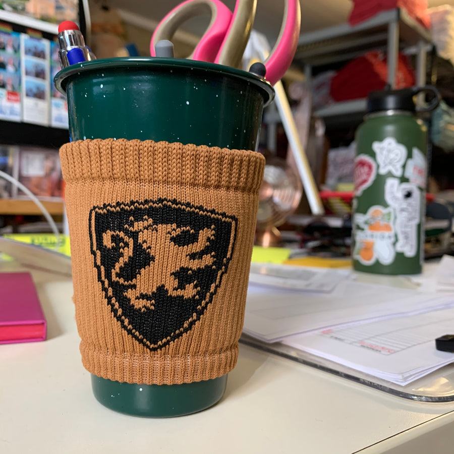brown coozie with black shield