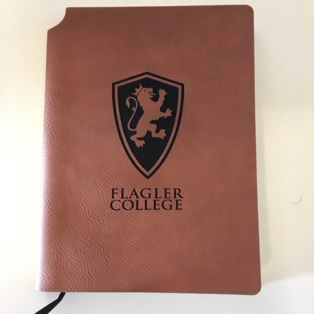 Brown velour journal with a large lion shield and "Flagler College" printed in black