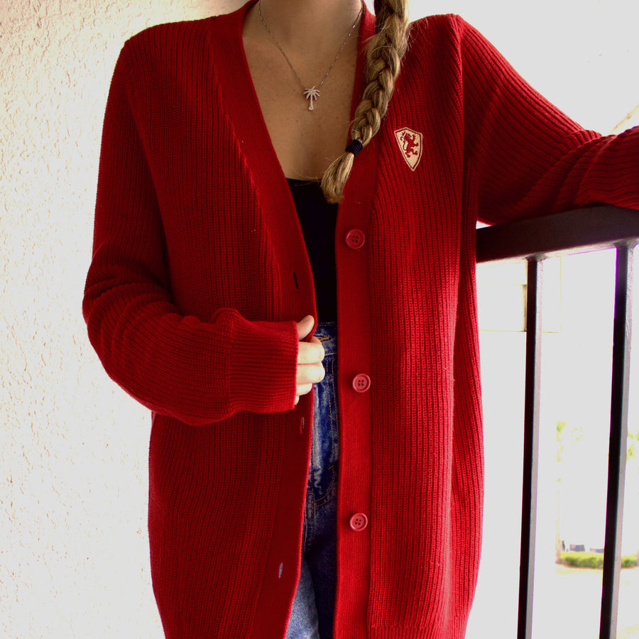 Zoomed in photo of red cardigan with golden Flagler College shield logo