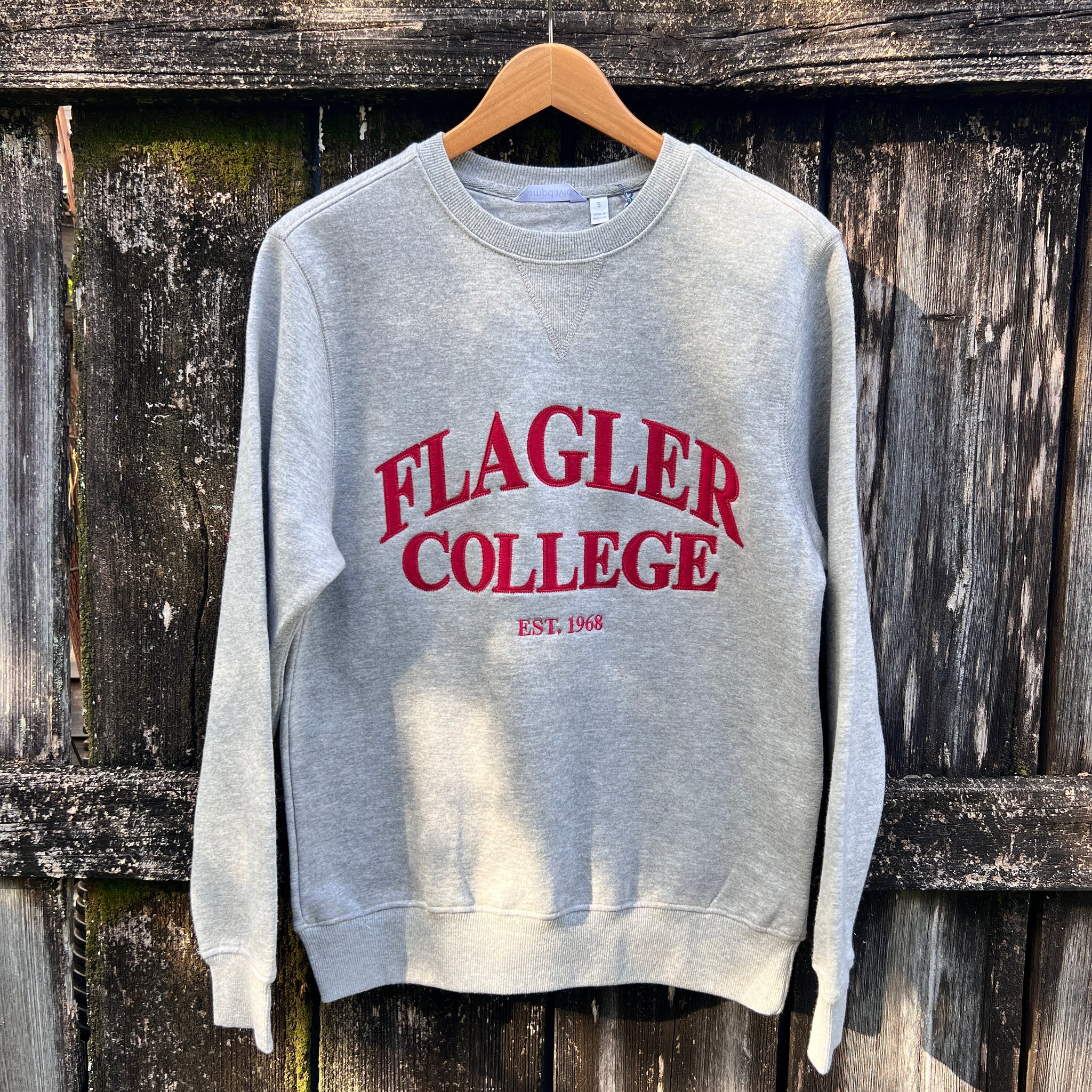 Grey solid longsleeve crewneck with crimson imprint in center saying Flagler over College over est 1968