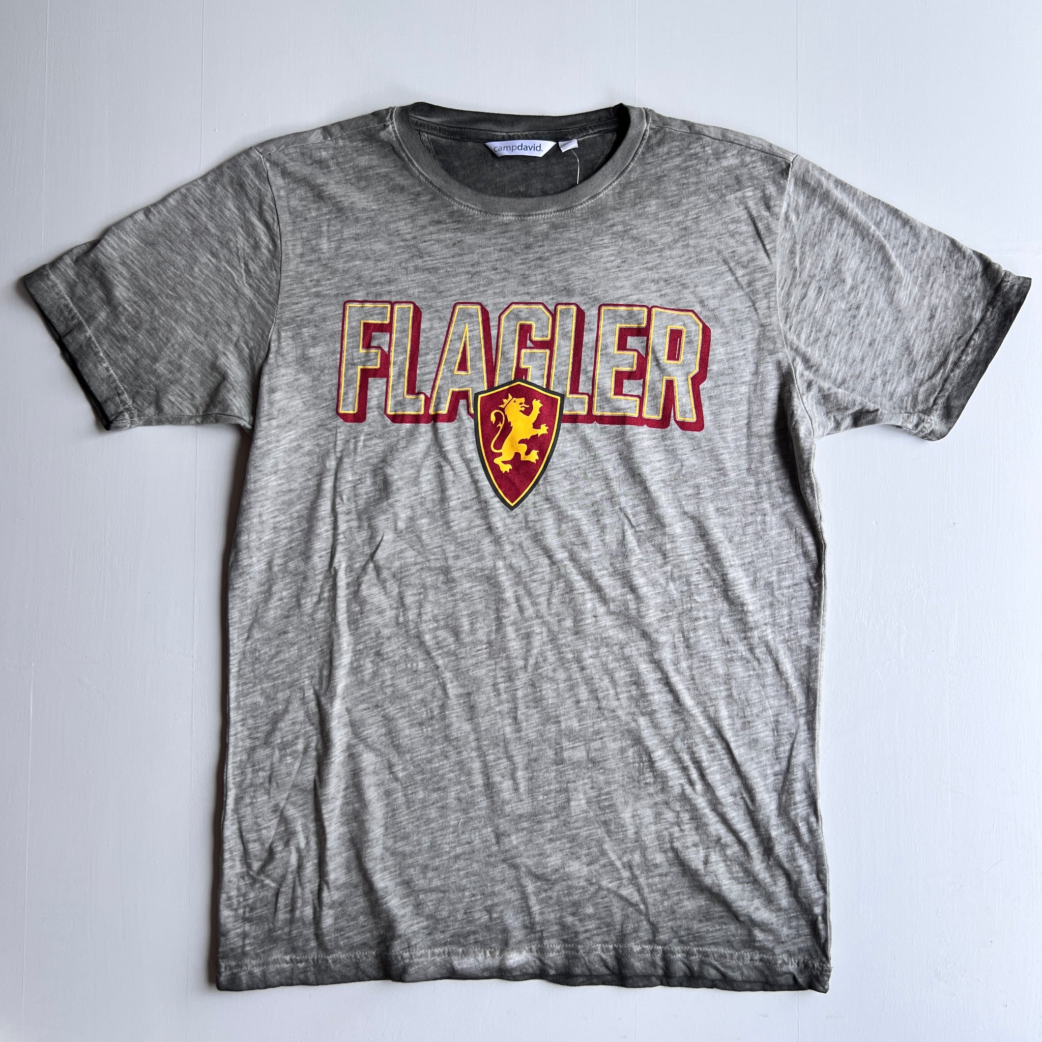 Dark Oxford color t-shirt with crimson imprint outlining saying Flagler over Flagler College Shield logo