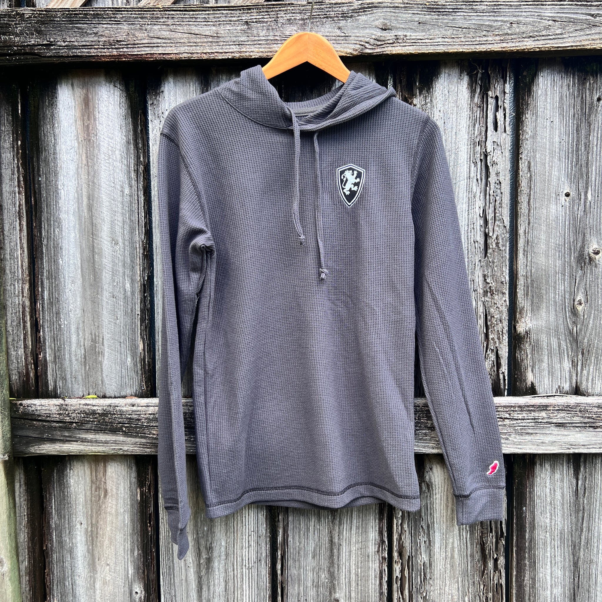 Charcoal hooded sweatshirt with waffle texture and black Flagler College shield logo on left side