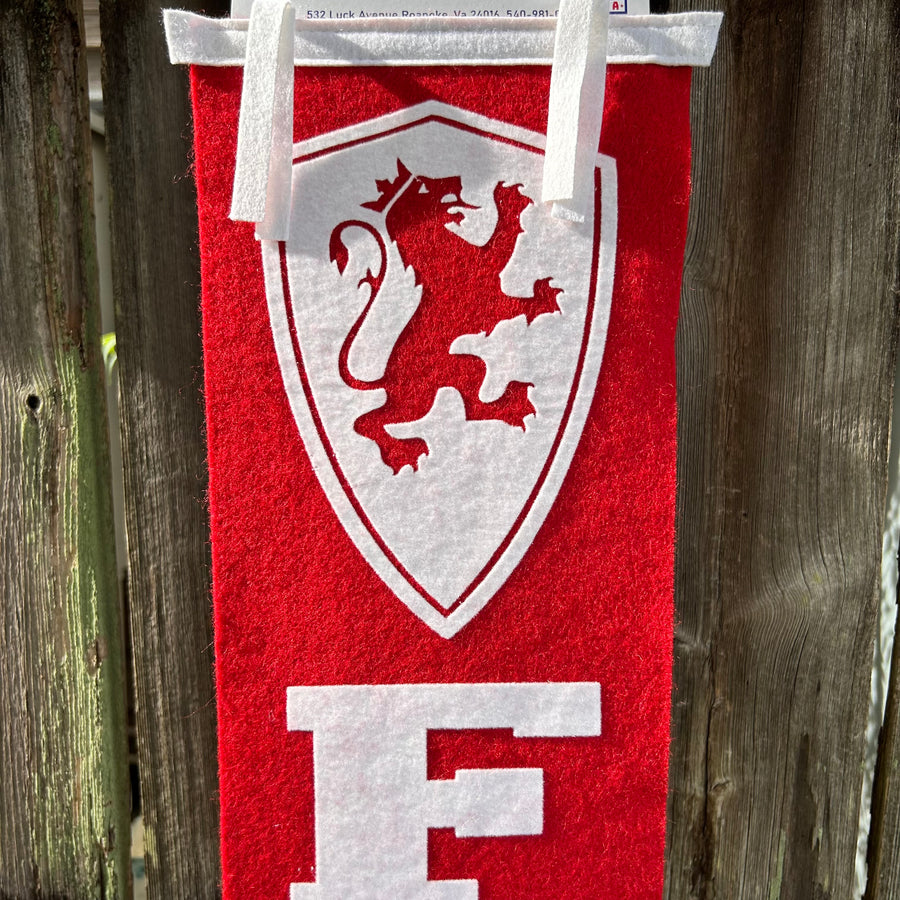 Extra long crimson and white pennant displayed on fence. 