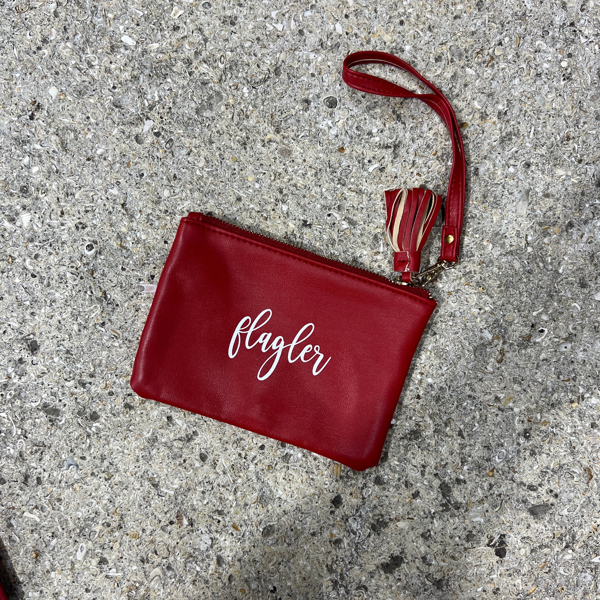 Crimson wristlet bag with white cursive imprint saying Flagler