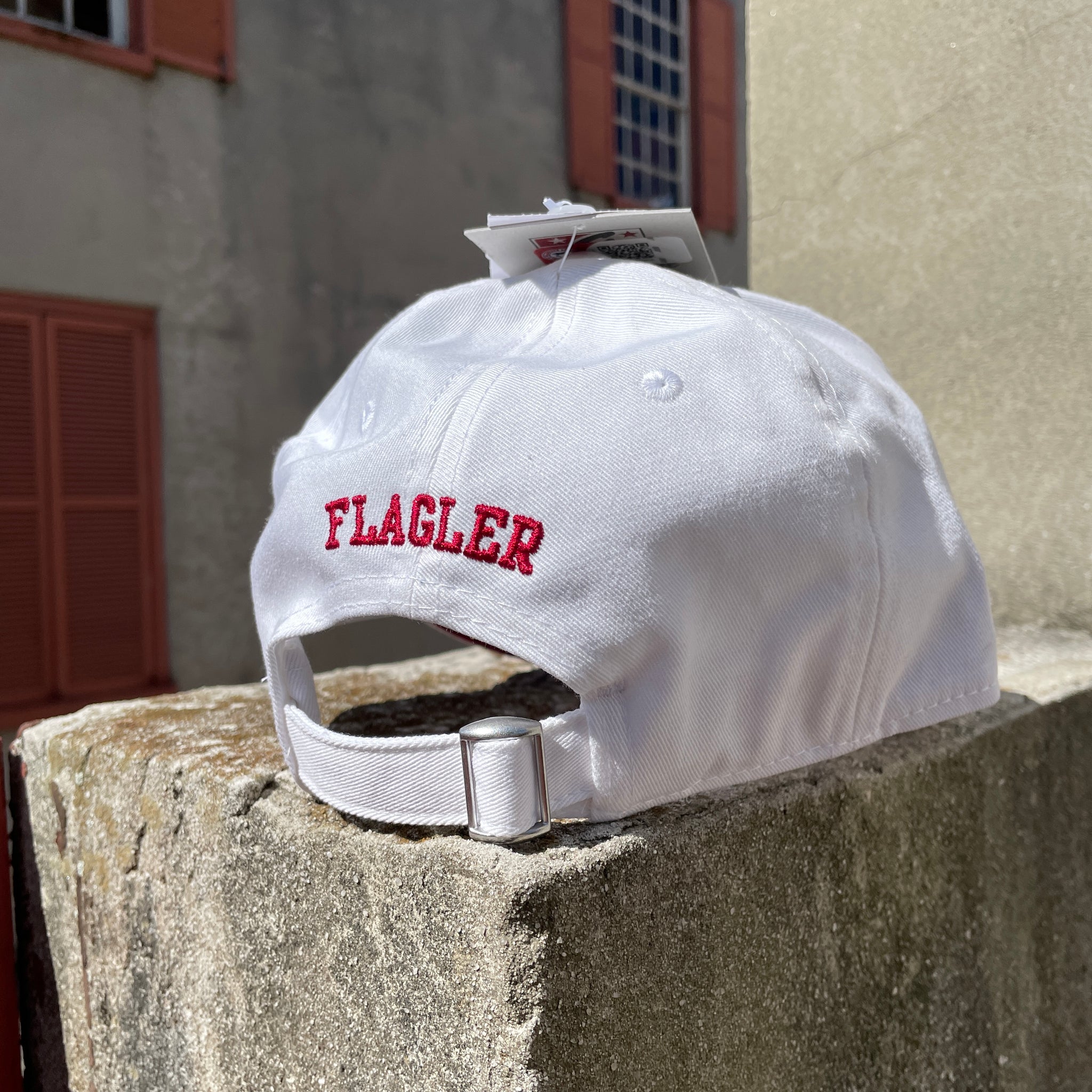 Back of white hat with crimson embroidering saying Flagler