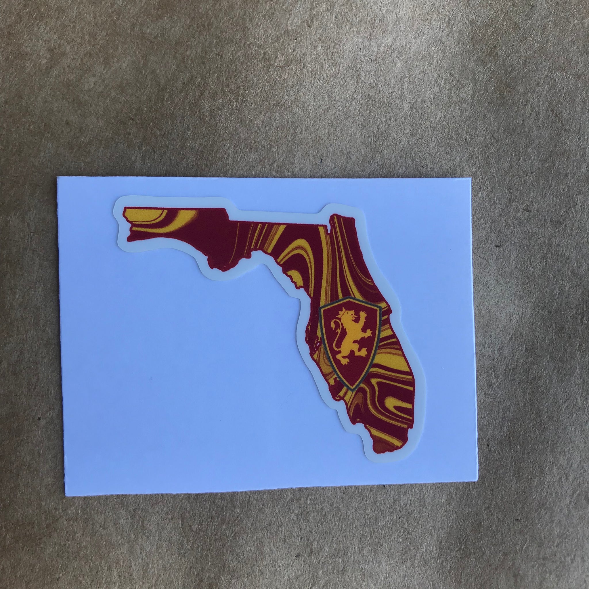red and yellow marble Florida state sticker with shield in middle