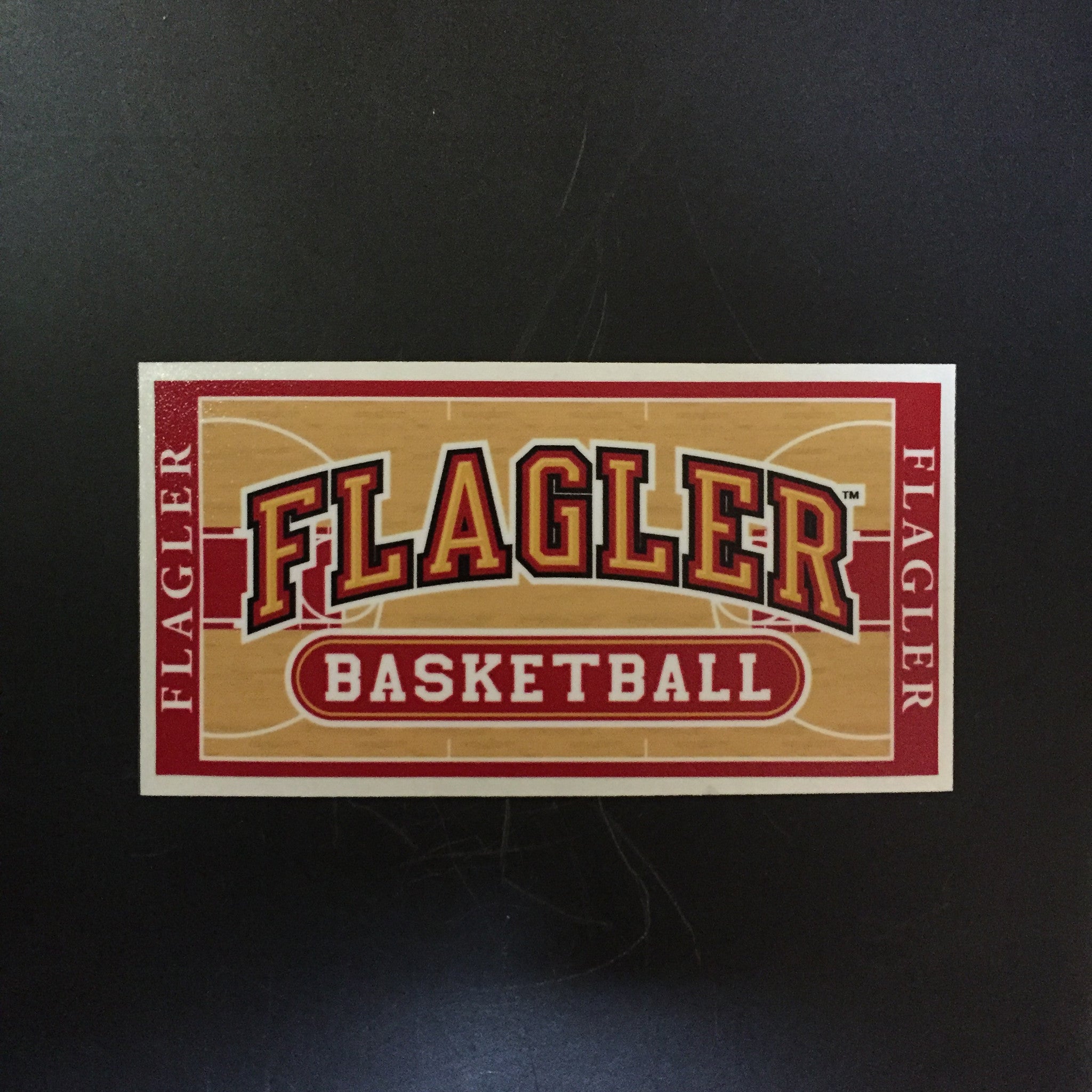 basketball court decal with Flagler written in gold and basketball written in white in red oval
