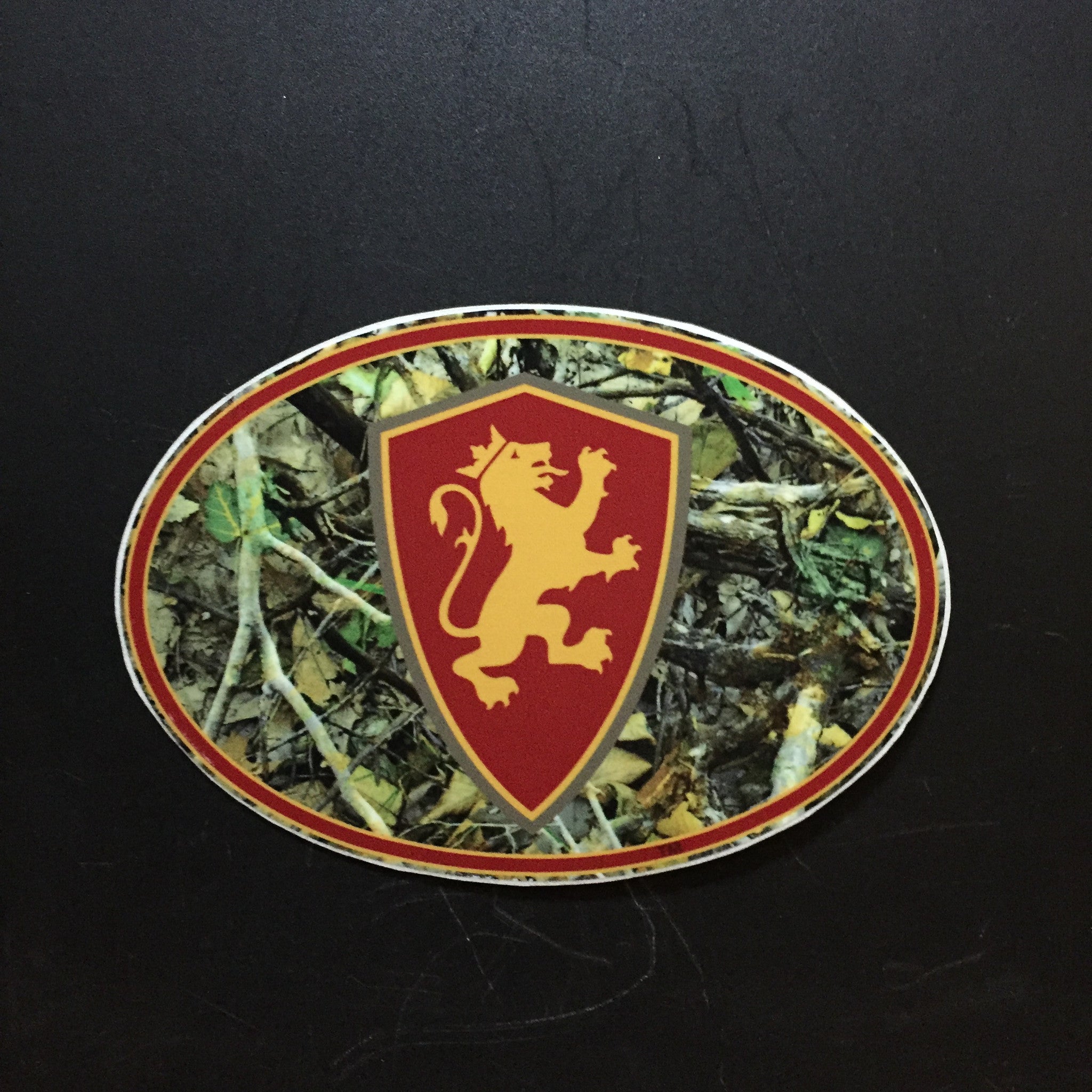 camo oval decal with gold and red lion shield. Oval is outlined in gold and red