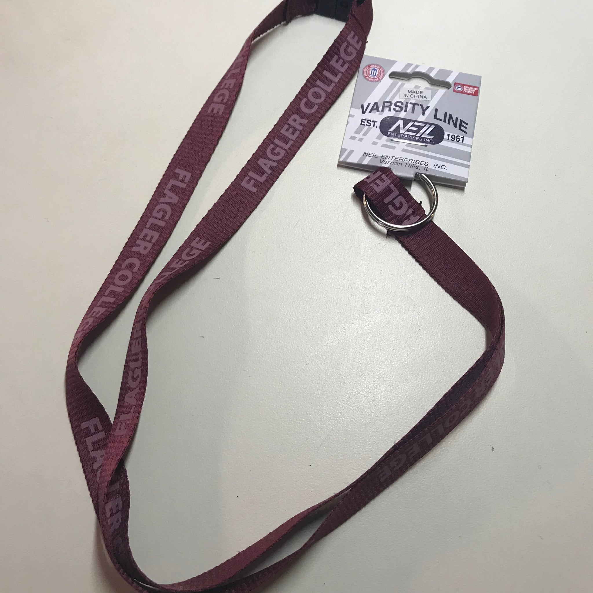 red lanyard with a pattern of Flagler College printed in a muted red