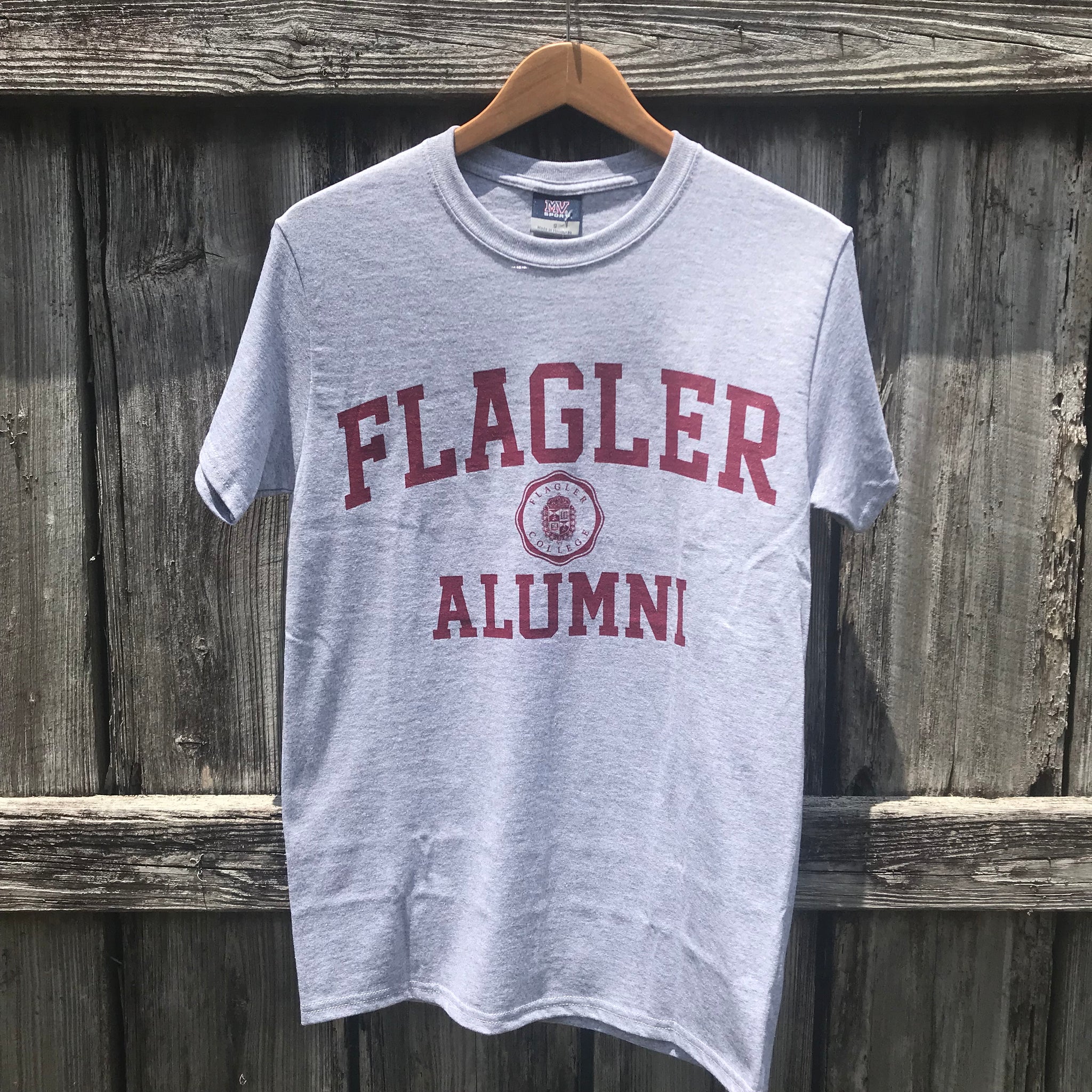 Grey t-shirt with Flagler alumni printed in red in middle of chest
