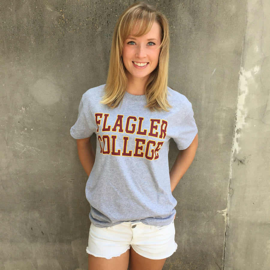 Grey t-shirt with crimson imprint saying Flagler College outlined in gold