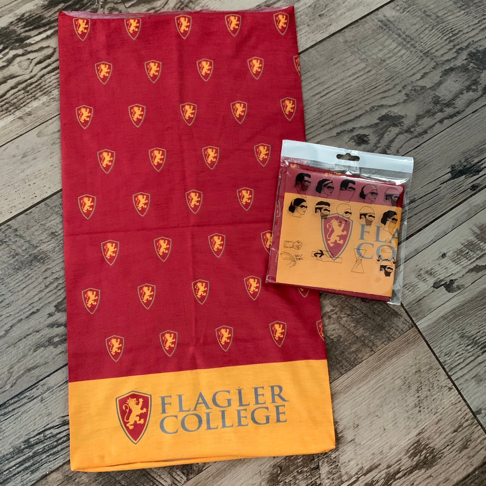 Gator next to packaging. Red fabric with flagler college shield logos over yellow bottom with big Flagler College shield next to grey letters saying Flagler over College